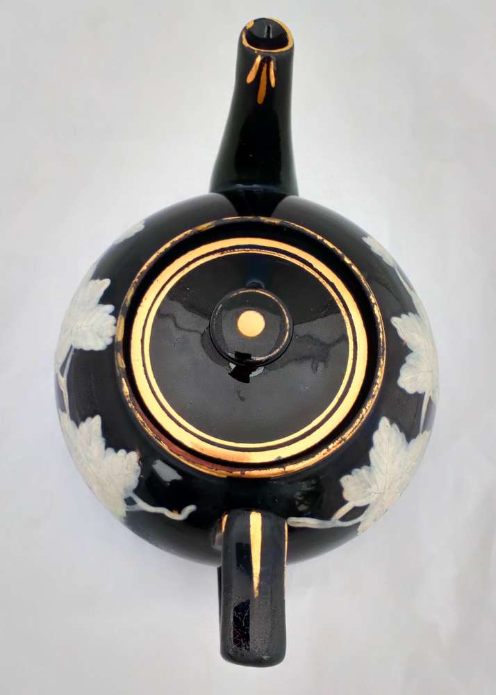 Victorian black glazed teapot with white enamelled vine leaves and stems antique circa 1850