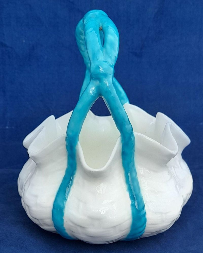 An antique moulded porcelain basket shaped posy bowl with turquoise enamel painted handle and pinched rim. It is unmarked other than the pattern number 1/536 painted on the base in iron red enamel. This pretty item dates to the Victorian era in the late 19th century circa 1875. 11.5 cm diameter , 13.4 cm high