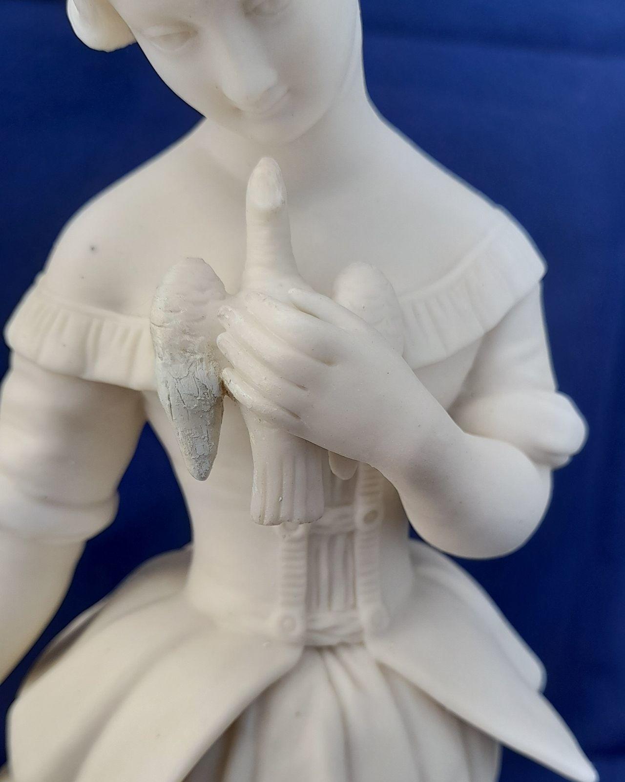 An antique Minton white Parian porcelain figurine of a young woman holding a bird symbolic of kindness and innocence circa 1845 29.5 cm high 1 kg in weight some collectors may refer to this as biscuit or bisque porcelain.