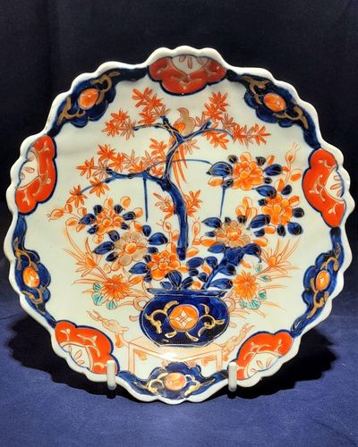 Antique Japanese Arita Porcelain Plate Scalloped Hand Painted Imari Meiji circa 1900 - Pattern of a Bird sat in a potted Acer tree which in turn is sat upon a table which has dragon decoration.