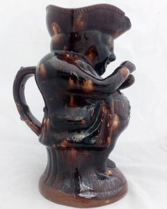 Antique pottery Rockingham brown treacle glazed toby jug known as the Snuff Taker 24 cm high dating from the 19th century circa 1880.