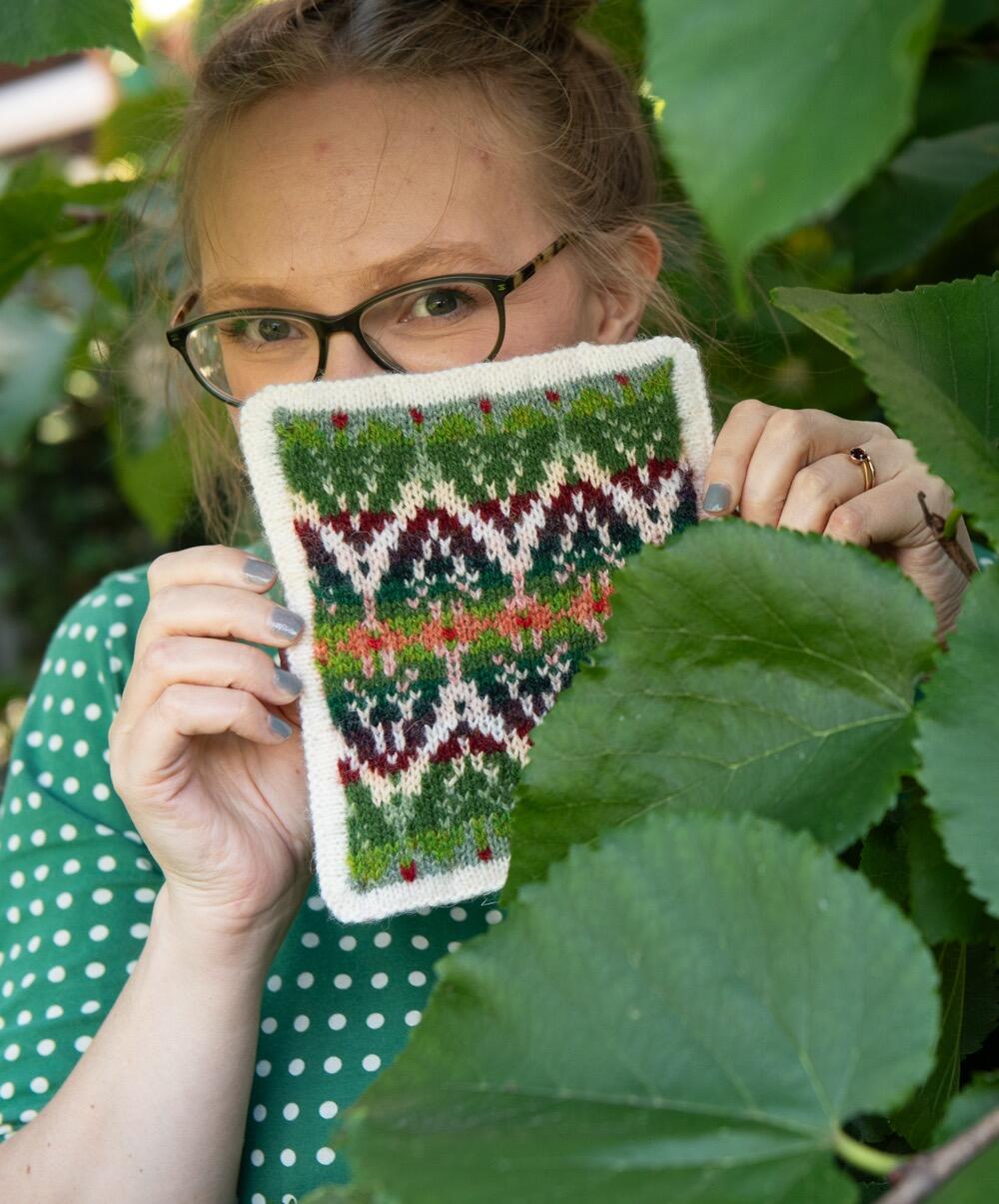 Felix peeps out of her Mulberry tree, holding up a postcard inspired by its leaves and fruits