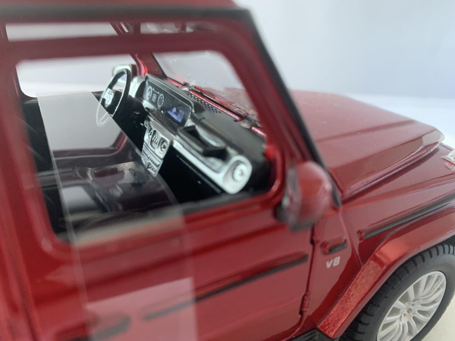 An excellent scale model of a Mercedes Benz G Class decorated in metallic red with sunroof and silver wheels.  Other trims are finished in chrome, black and silv