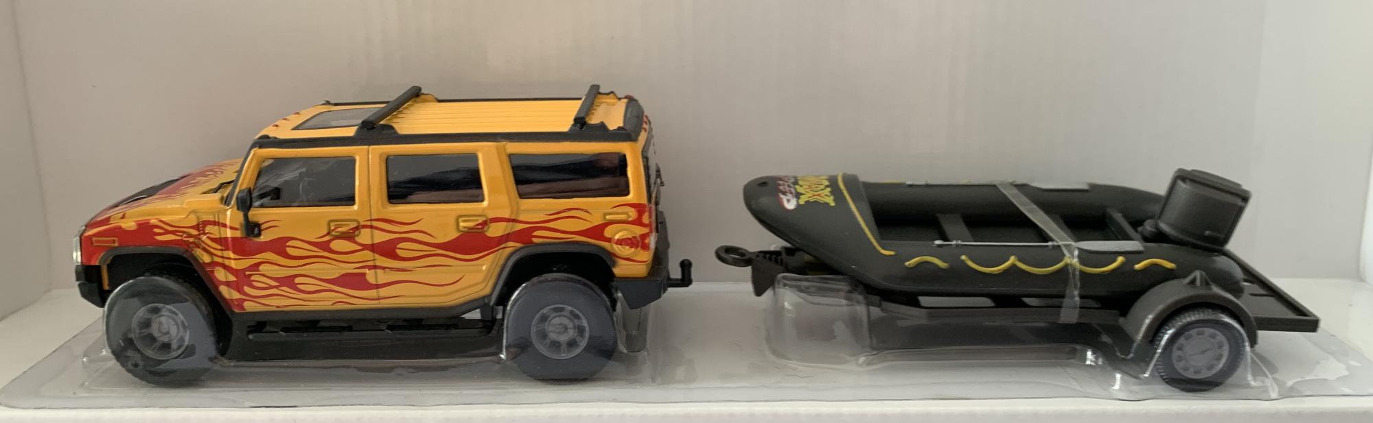 Hummer in yellow with red flame effect and inflatable style boat in grey  on trailer