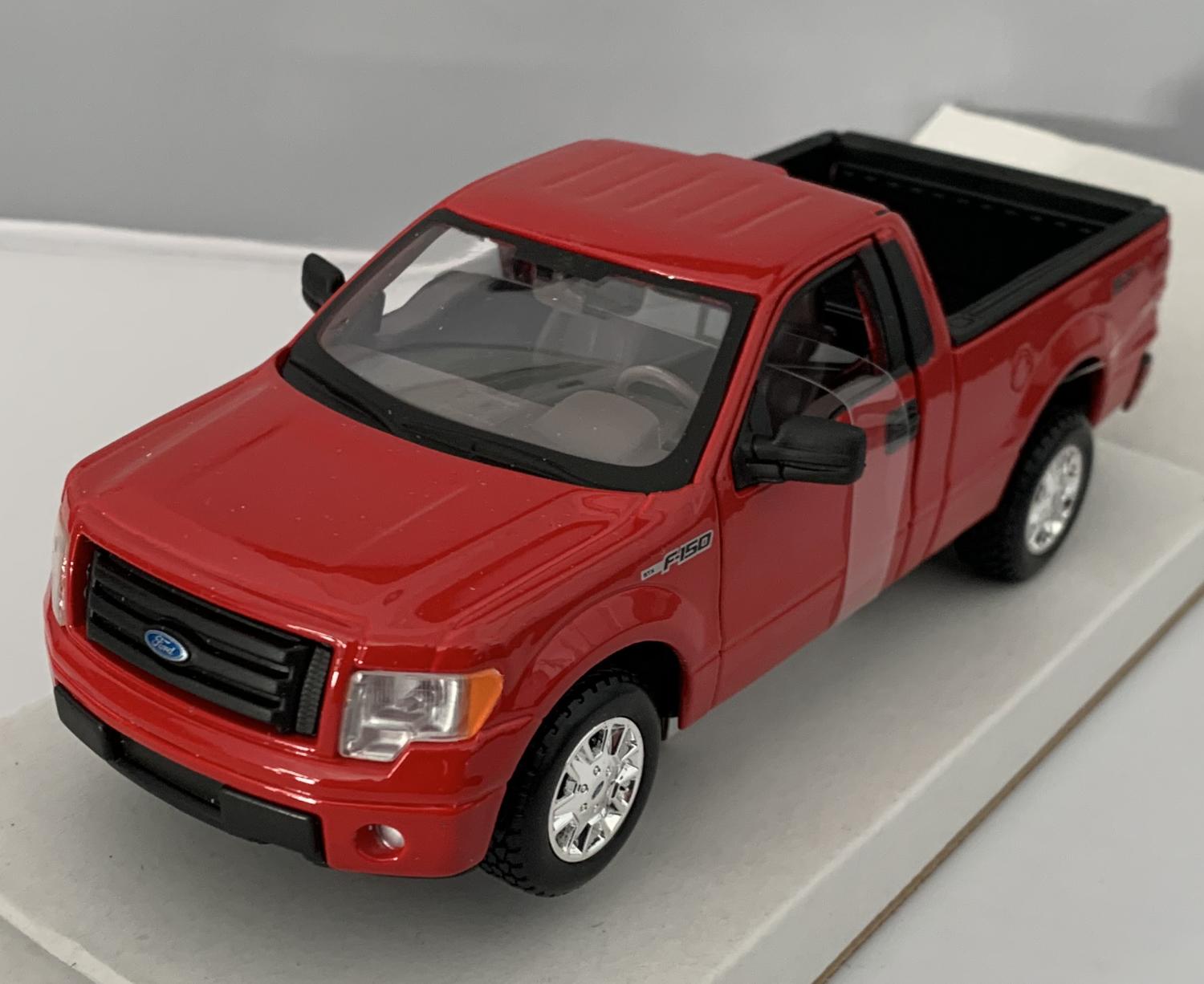 An excellent scale model of a Ford F-150 STX decorated in red with chrome wheels.