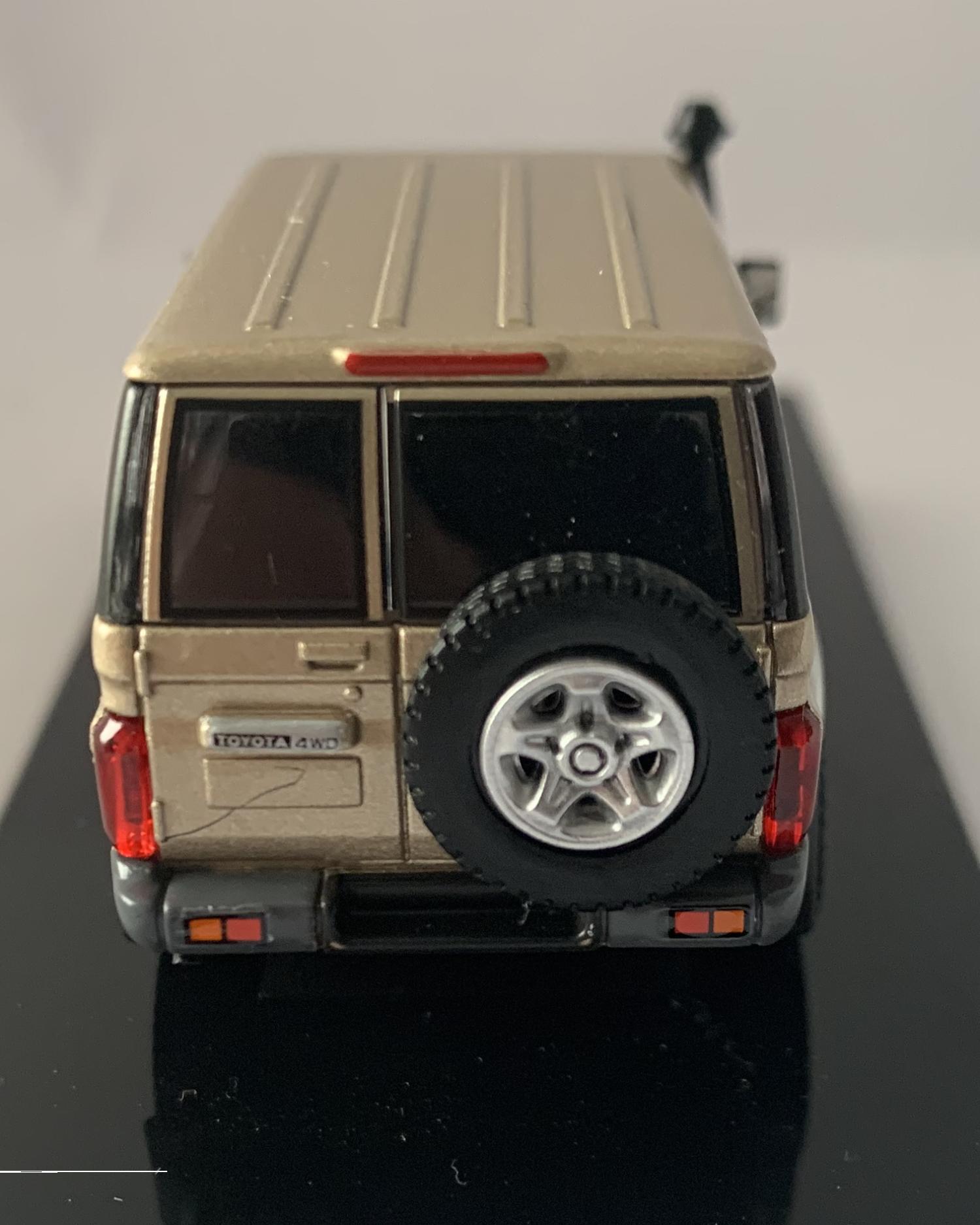 An excellent scale model of a Toyota Land Cruiser decorated in vintage gold with silver wheels, spare wheel (not removable) on rear door and snorkel.