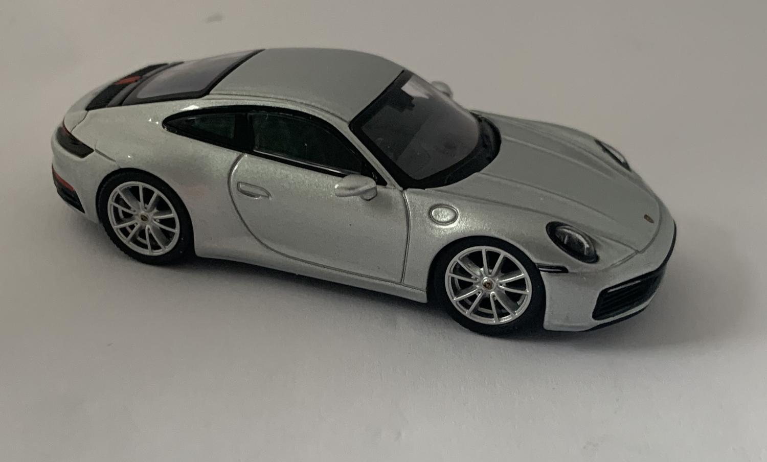 An excellent scale model of a Porsche 911 Carrera 4S decorated in silver metallic with silver wheels. Other trims are finished in black and silver. Features include working wheels. The interior is finished in black with RHD steering wheel