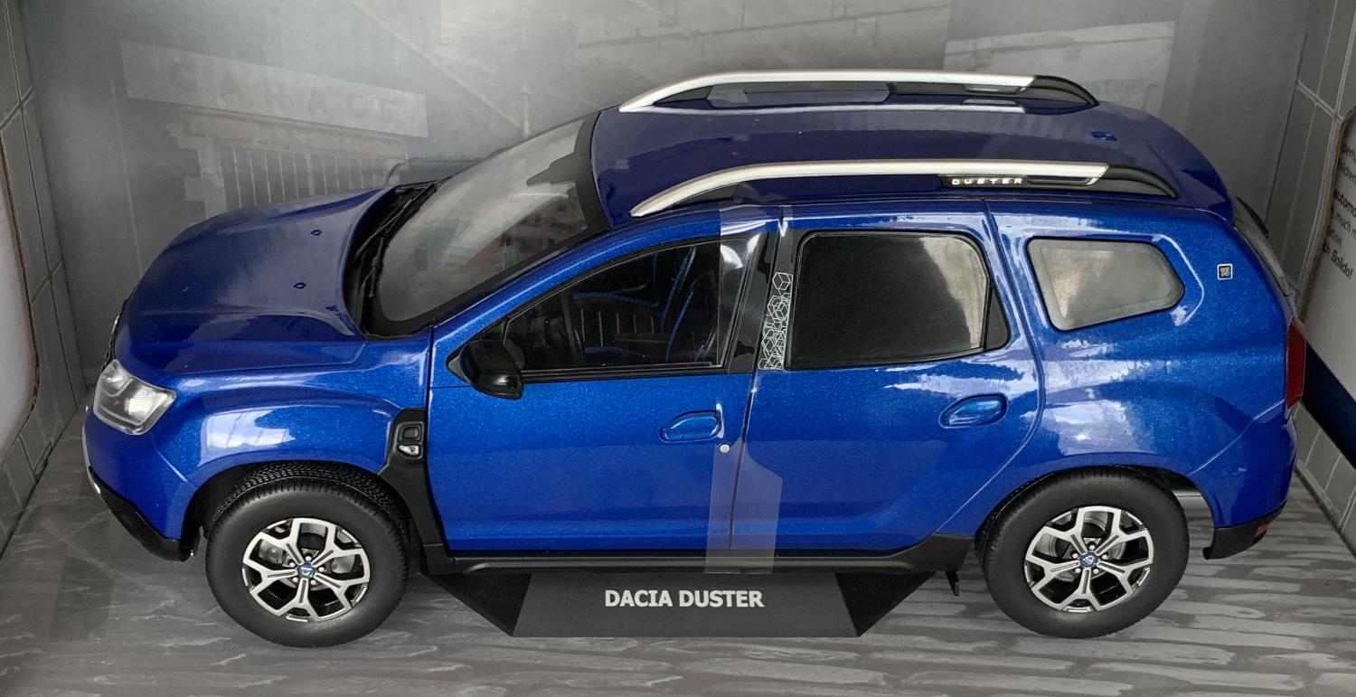A very good representation of the Dacia Duster decorated in blue cosmos with roof rails, blacked out rear windows with chrome and black wheels. Features include working wheels, opening driver and passenger doors