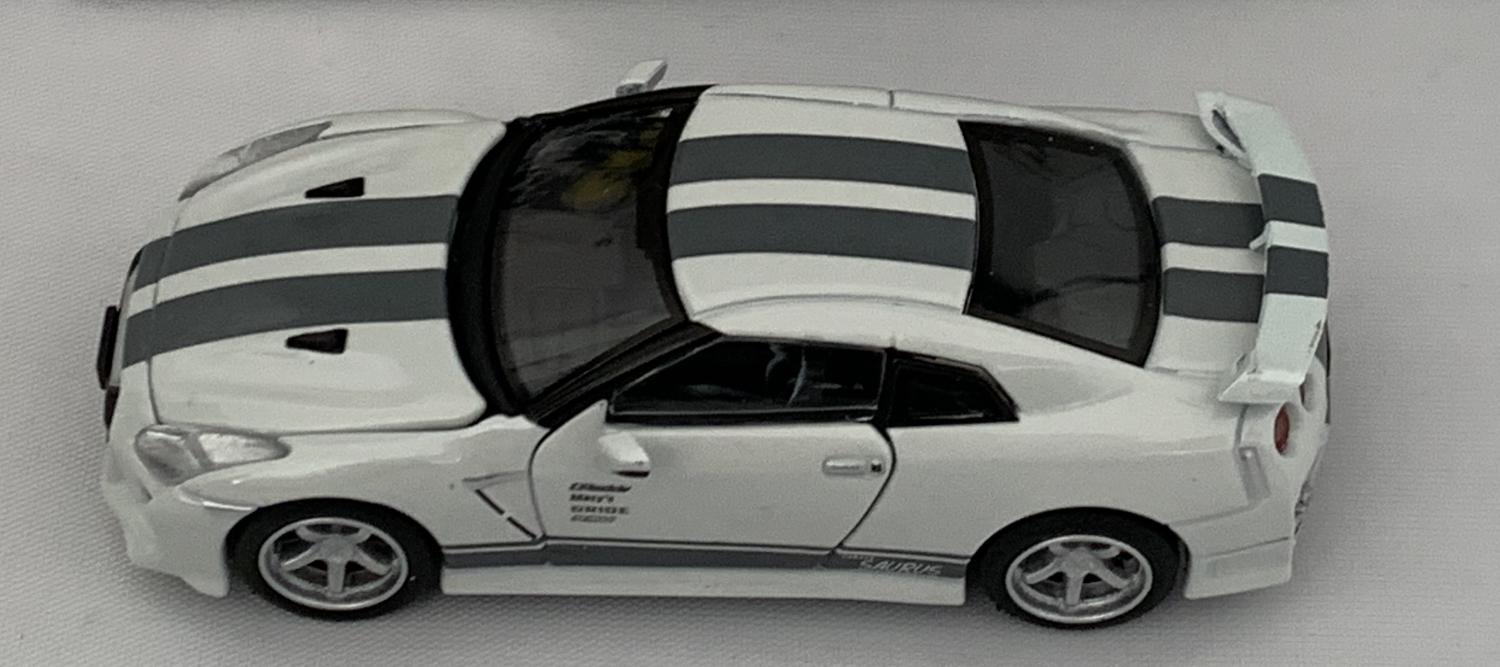 Nissan GT-R (R35) Advan X Sauras 2020 in white / black stripe 1:64 scale model from Era Car