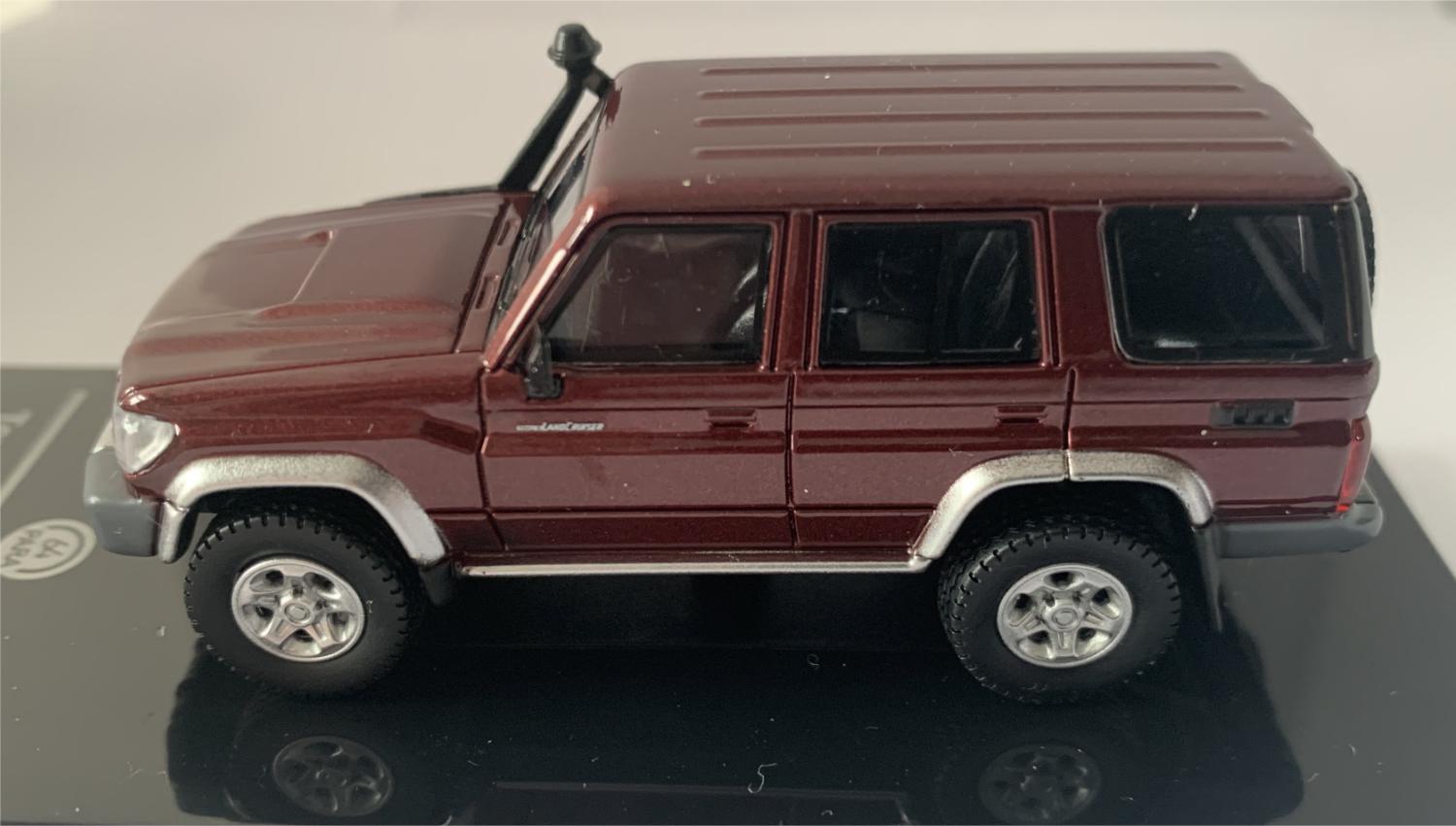 An excellent scale model of a Toyota Land Cruiser decorated in merlot red with silver wheels, spare wheel (not removable) on rear door and snorkel