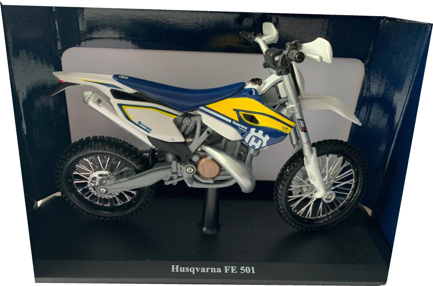 Husqvarna FE 501 in white / blue / yellow 1:12 scale model from Maisto, mounted on a plinth in a Husqvarna themed box