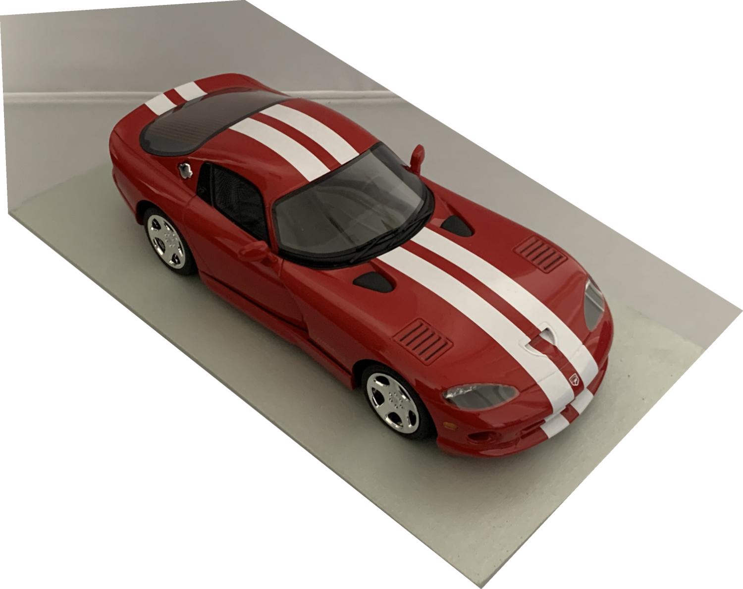 A very good representation of the Dodge Viper GTS from 2002 decorated in red with white stripes, bonnet and side air vents, twin exhausts and chrome wheels.