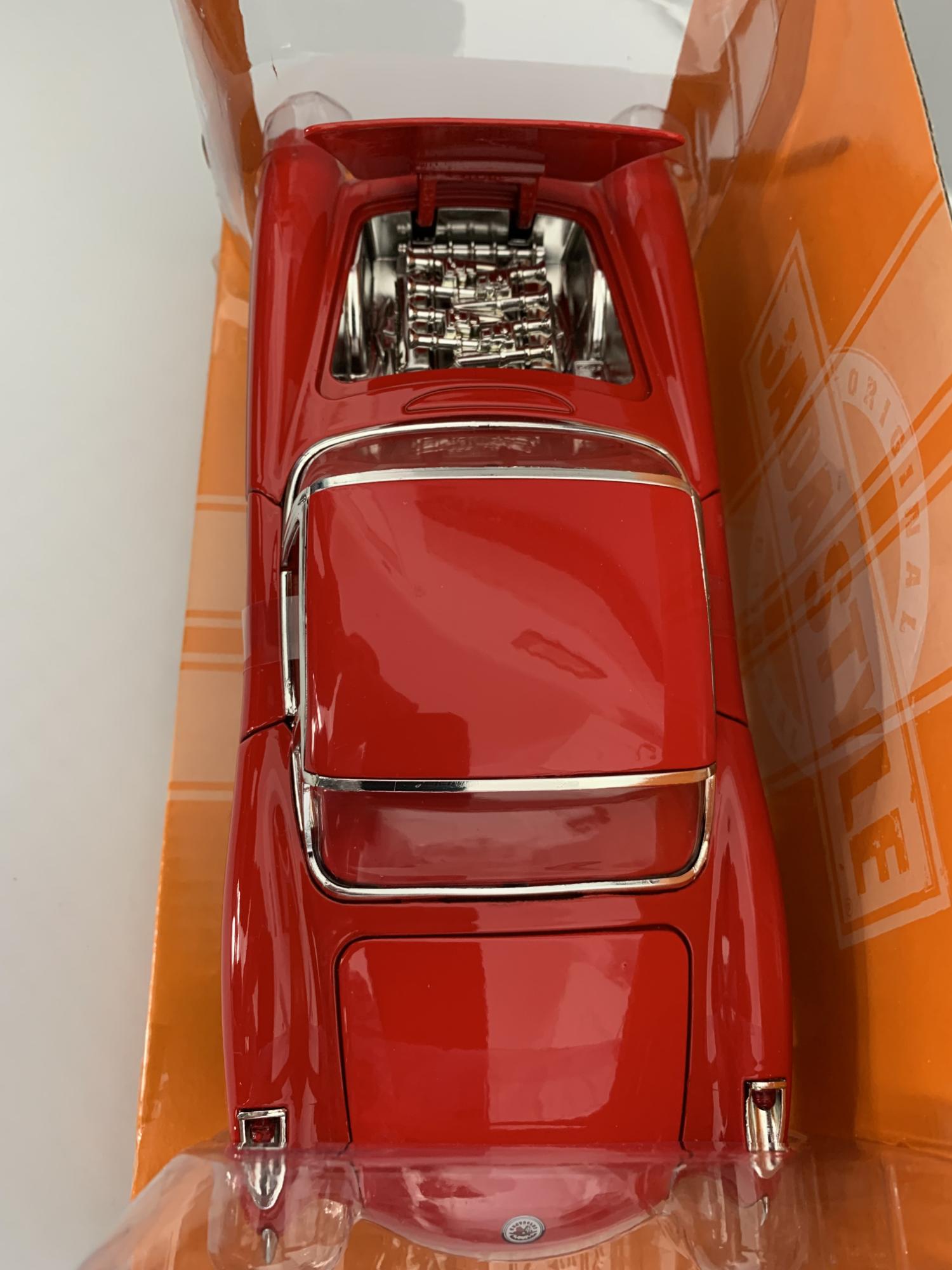 excellent scale model of a Chevy Corvette decorated in red and white with chrome wheels.