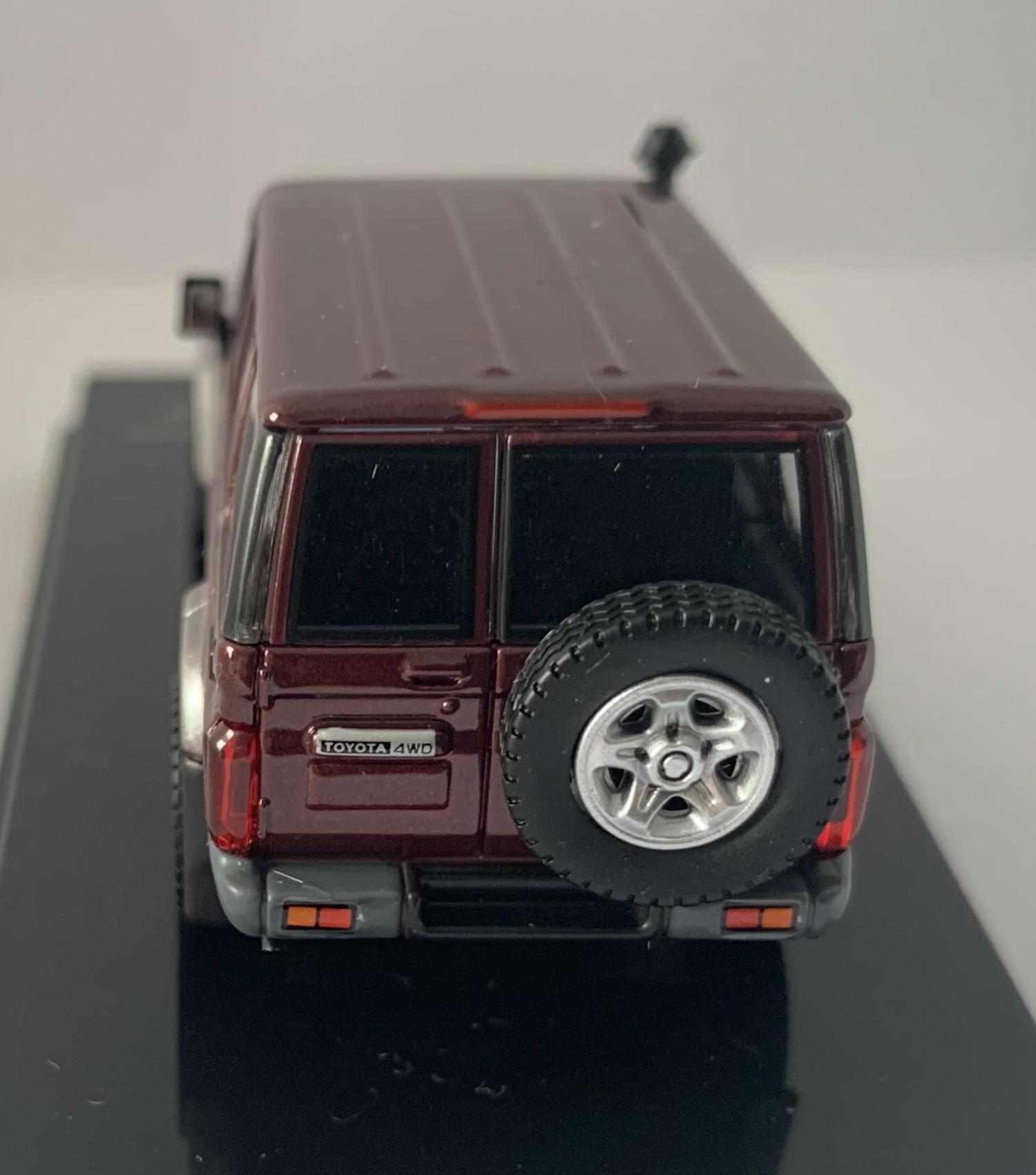 An excellent scale model of a Toyota Land Cruiser decorated in merlot red with silver wheels, spare wheel (not removable) on rear door and snorkel