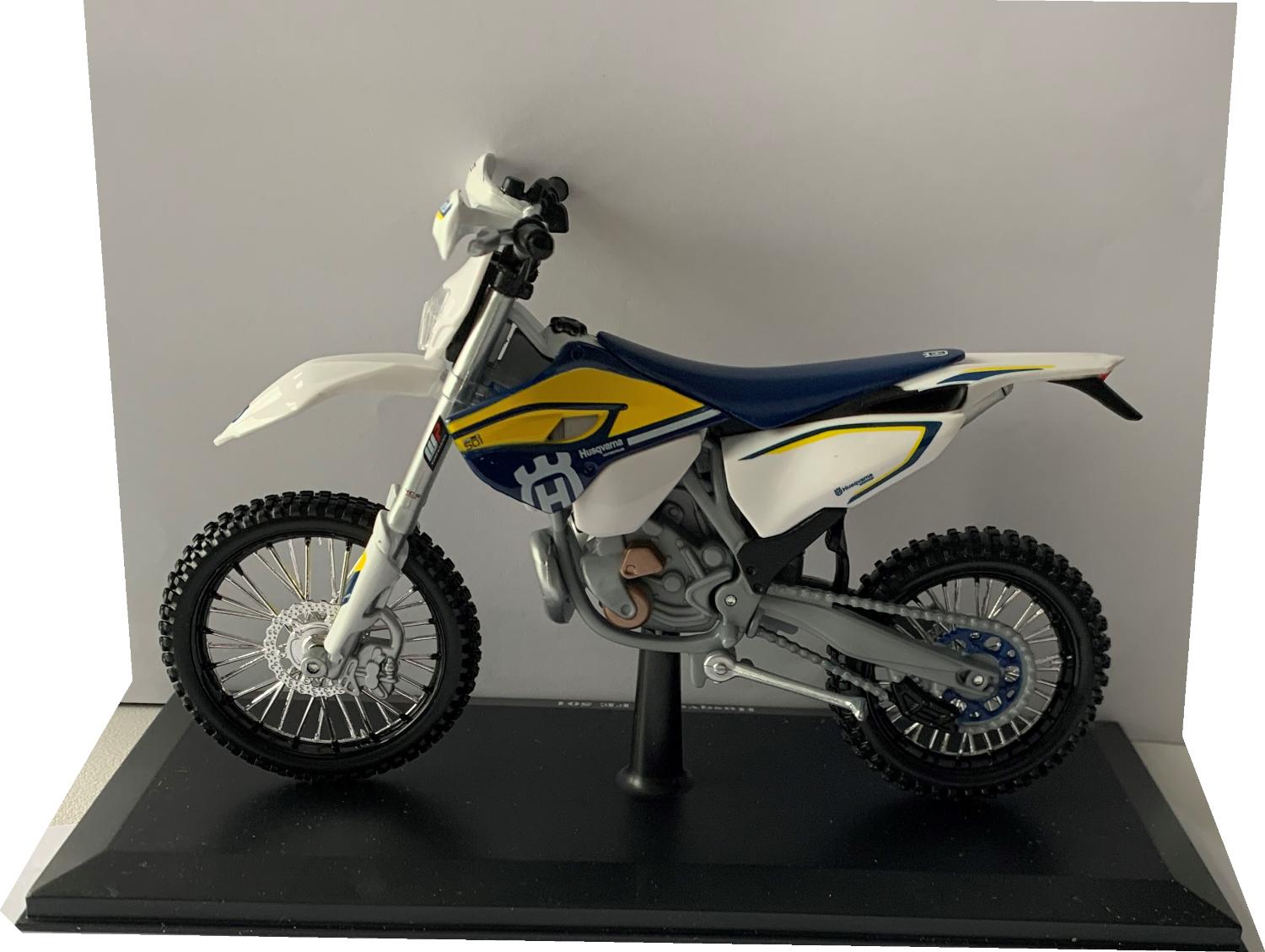 usqvarna FE 501 in white / blue / yellow 1:12 scale model from Maisto, mounted on a plinth in a Husqvarna themed box