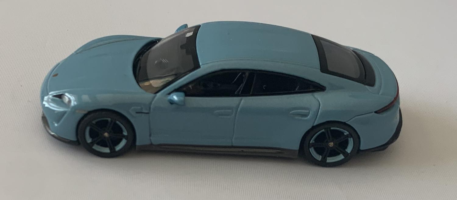 An excellent scale model of a Porsche Taycan Turbo S decorated in frozen blue metallic with black and frozen blue wheels.