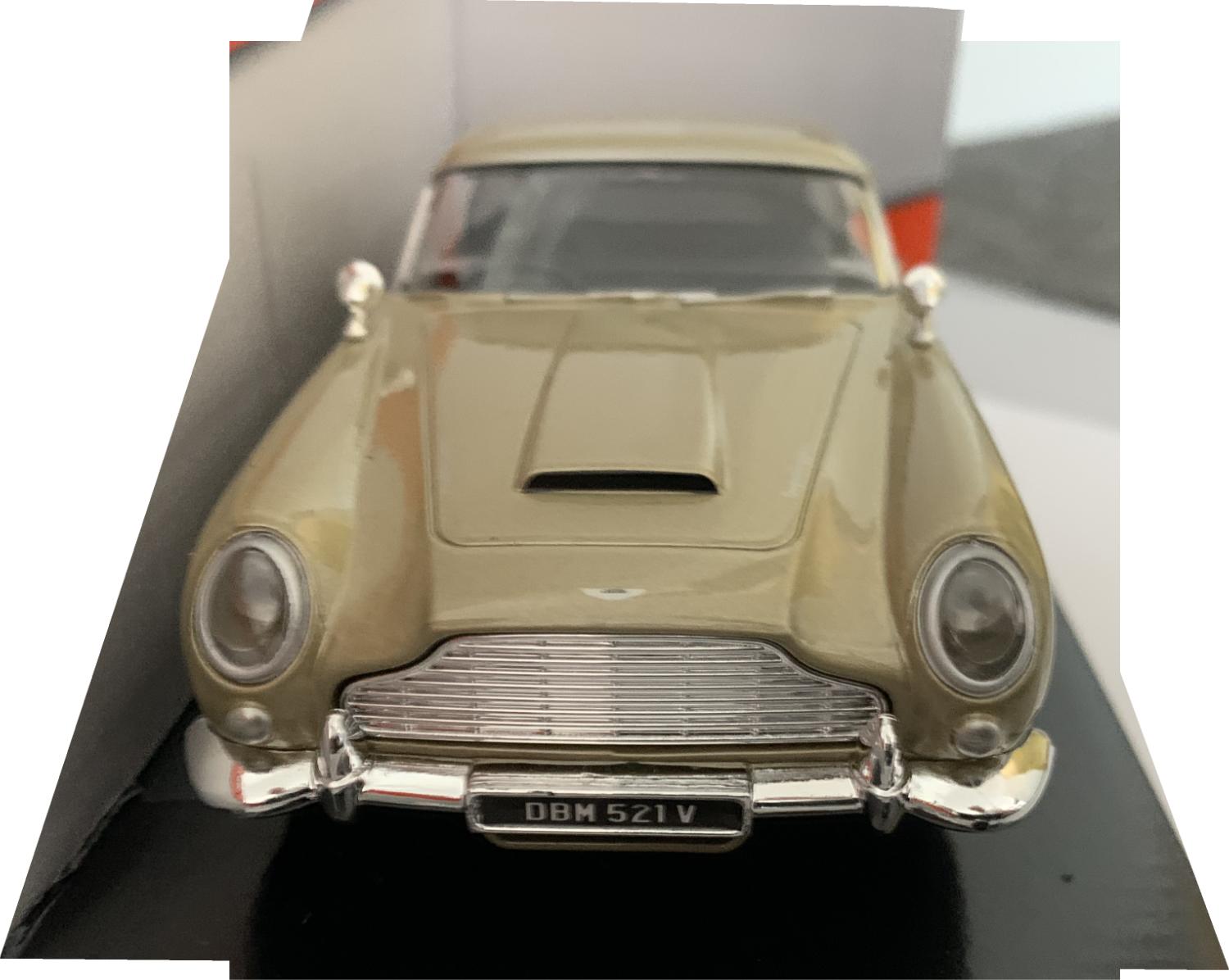 An excellent scale model of an Aston Martin DB5 decorated in gold with wired chrome wheels and body air vents.