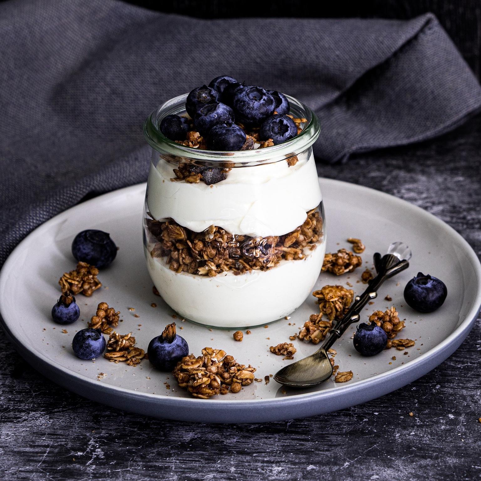 A jar of natural yogurt with muesli and blueberries
