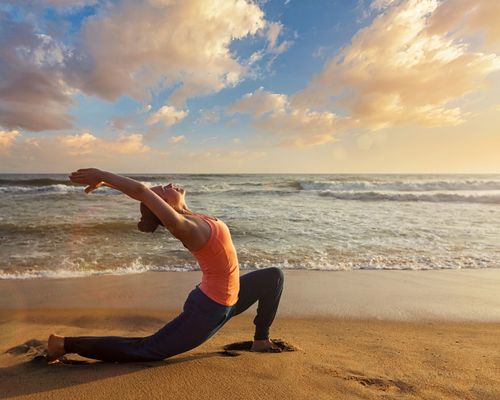 Lady Practising Yoga on Beach on Yoga Holiday- Yoga United