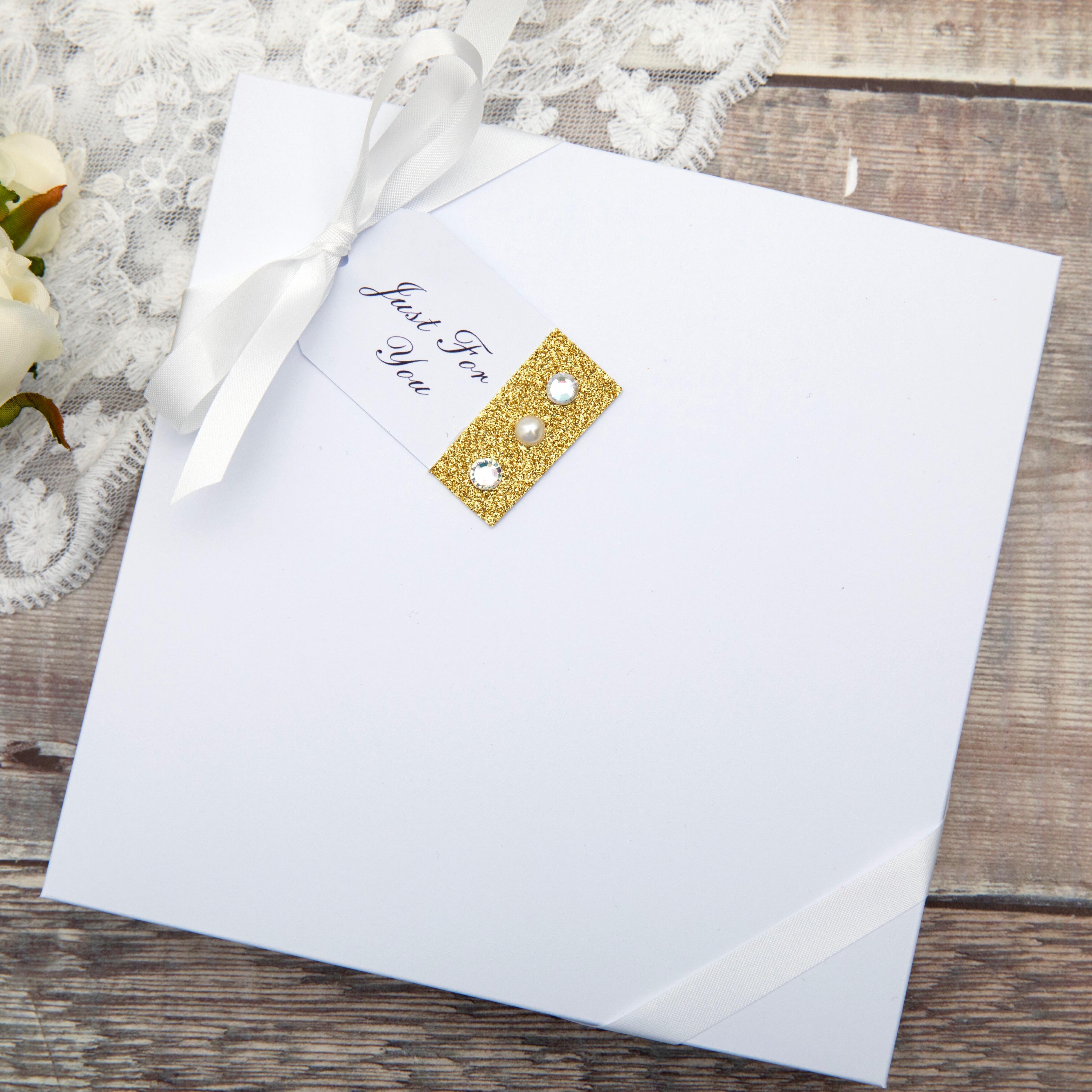 a gift box features a white ribbon bow and decorated tag on a wooden background