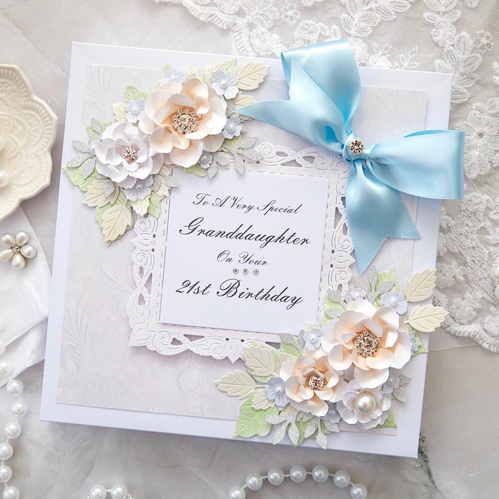 A handmade card featuring arch shaped frame surrounded by handmade floral displays of foliage and 3d flowers