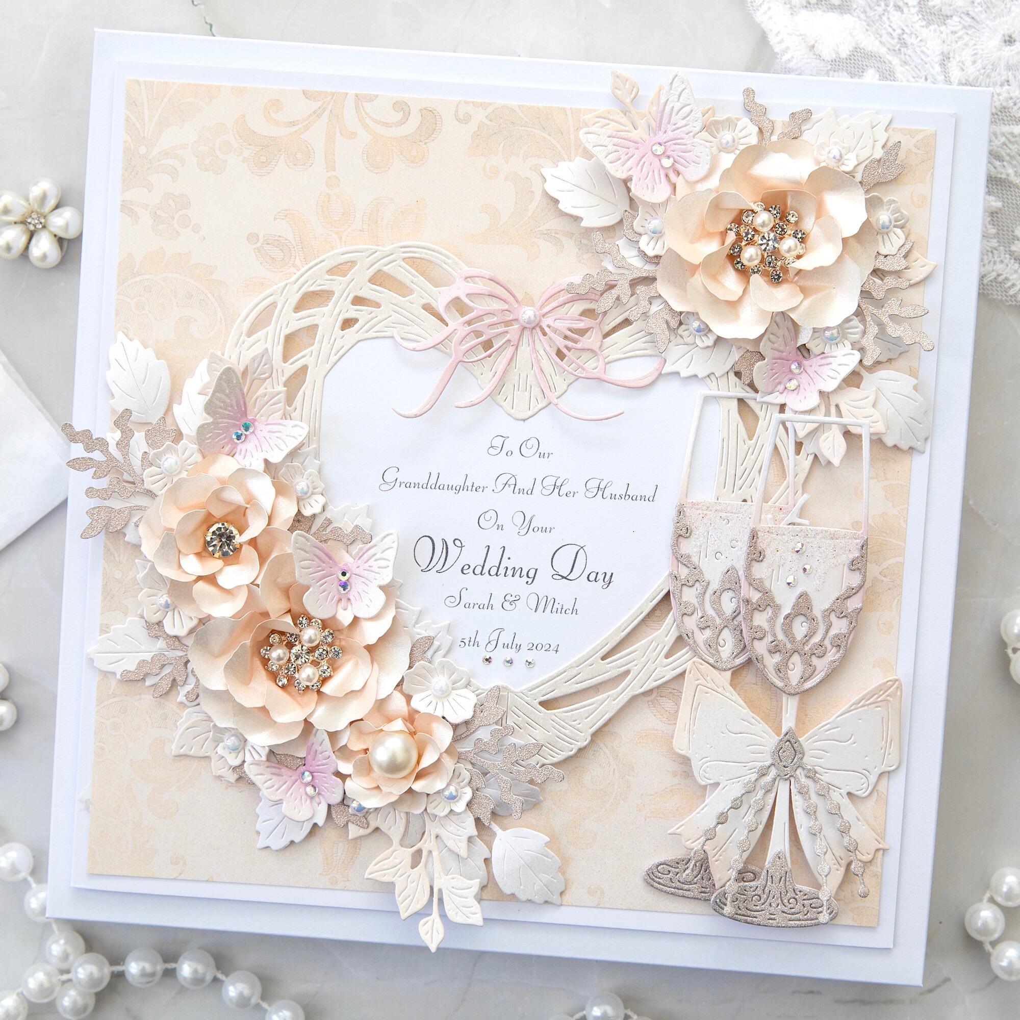 A square greeting card sits against a white lace background covered in ivory and white pearls