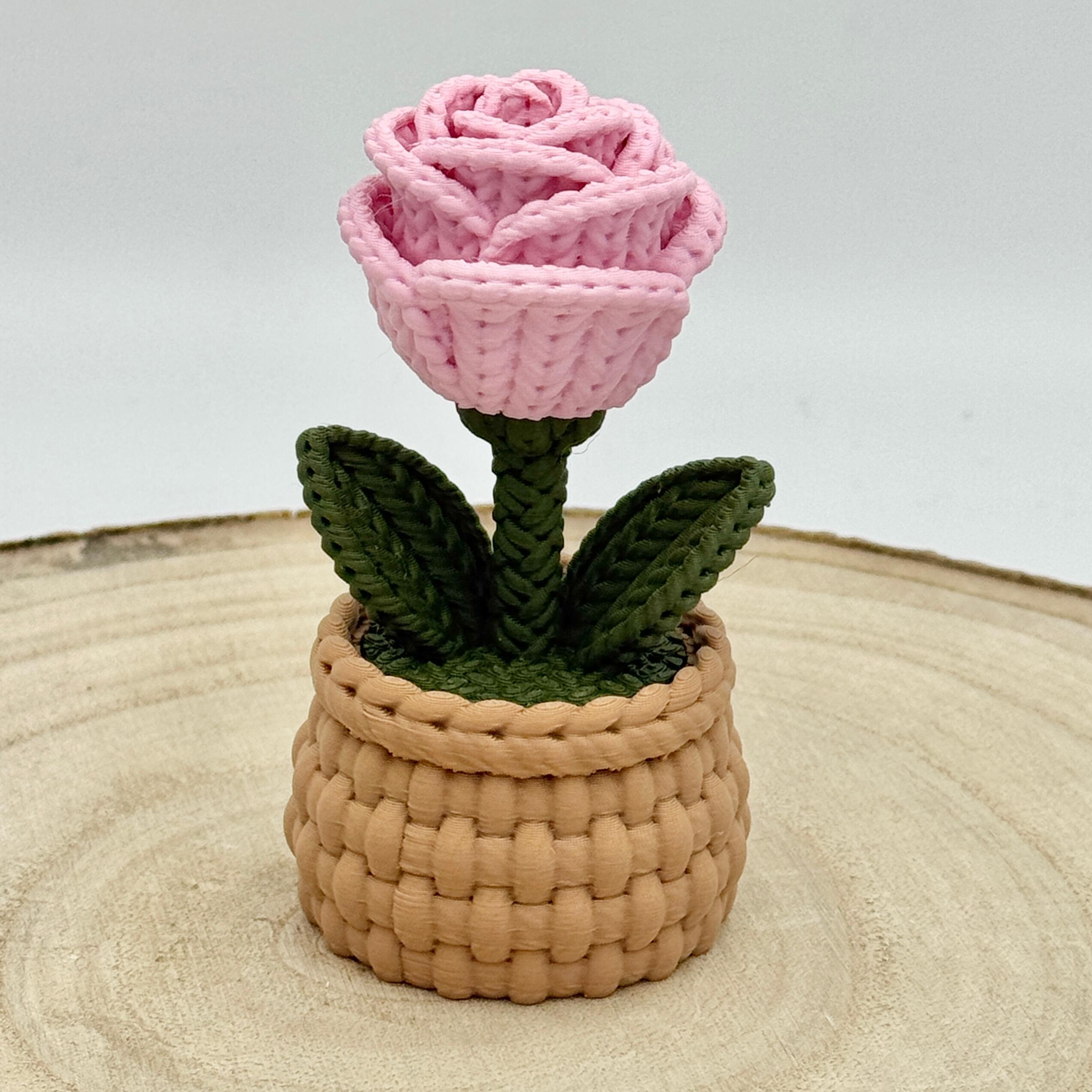 pink knitted effect roses in a light brown woven basket