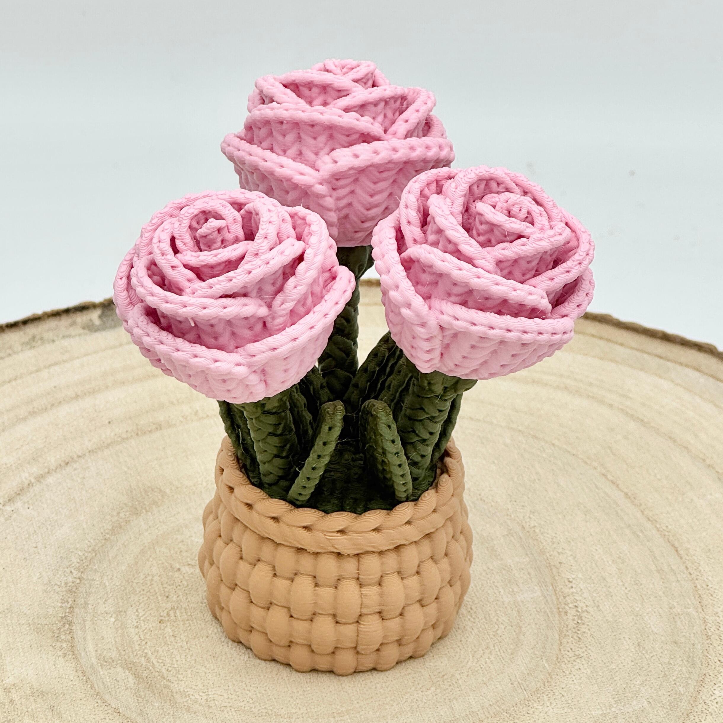 pink knitted effect roses in a light brown woven basket