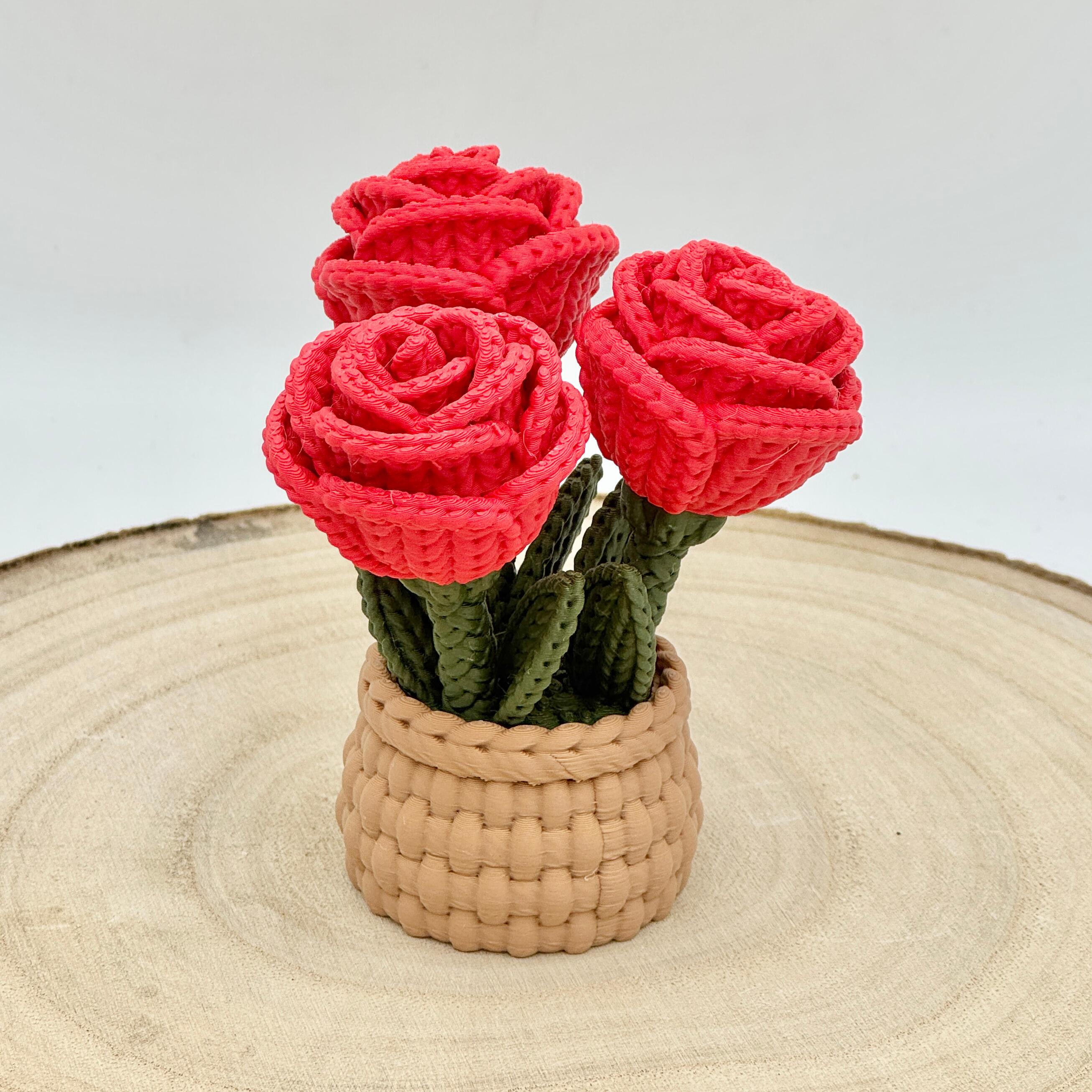 red knitted effect roses in a light brown woven basket