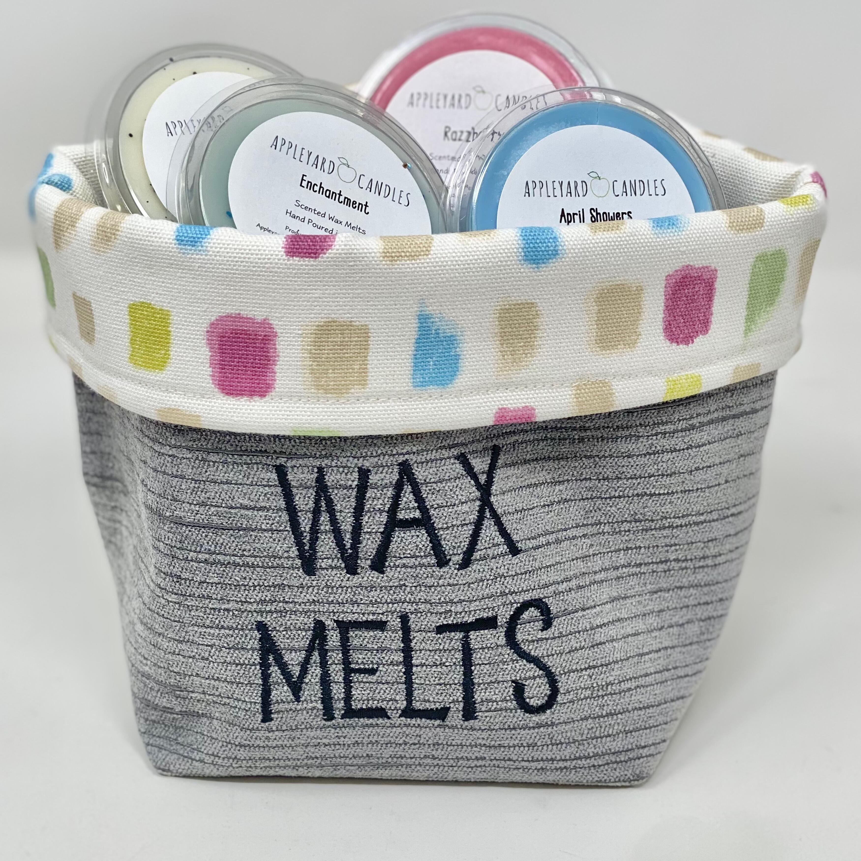 an image of a handmade fabric basket that reads wax melts on the front, containing a selection of handamde wax melts