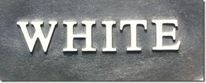 The word White on a plain lead sign painted in white