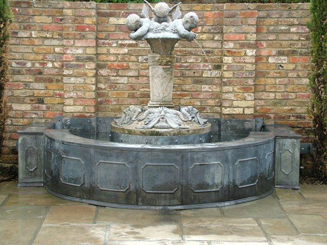 Lead wall frensham panel fountain with spouting cherubs in claph
