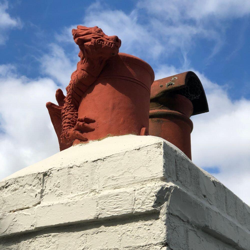 Chimney pot dragon terracotta on a chimney