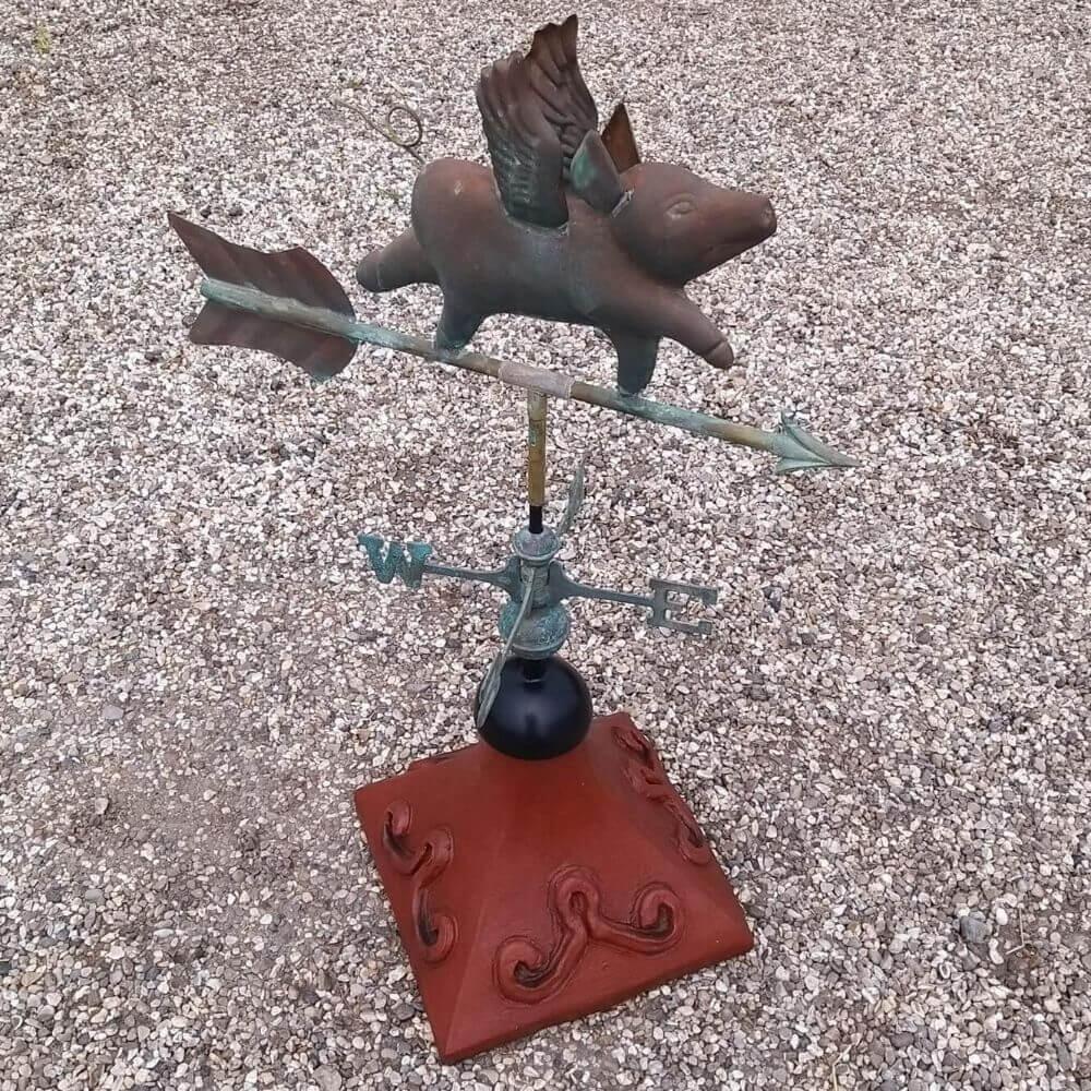Flying pig weathervane fitted on a square ridge tile