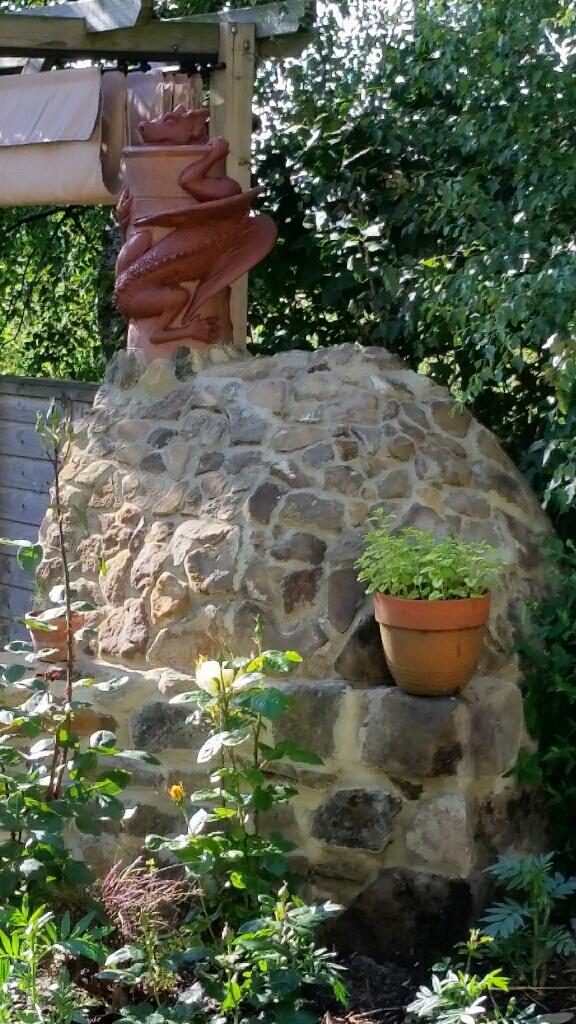 Pizza oven made of stone with a terracotta dragon chimney pot