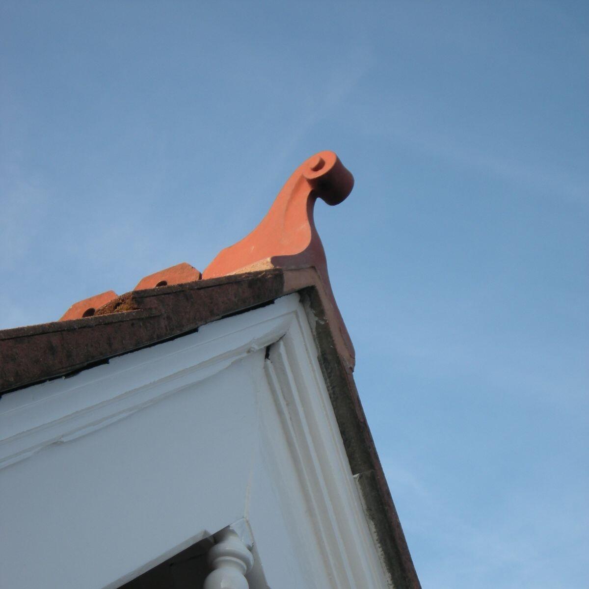 Small swan neck roof finial installed on a roof