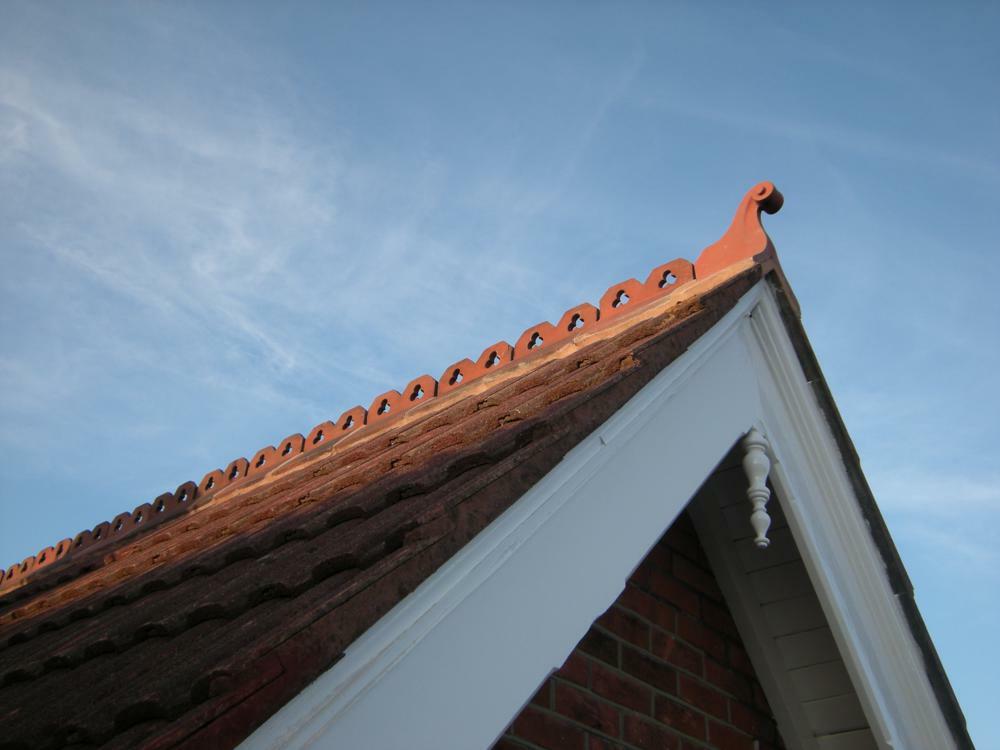 Swan neck finial matching to club crested ridge tiles on the roof