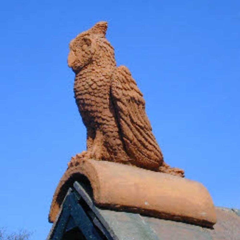 A roof that has a roof finial in the form of a terracotta owl installed on it
