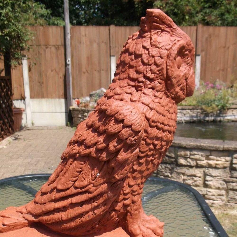 Photograph taken in the garden depicting a terracotta owl roof finial stop end stop end