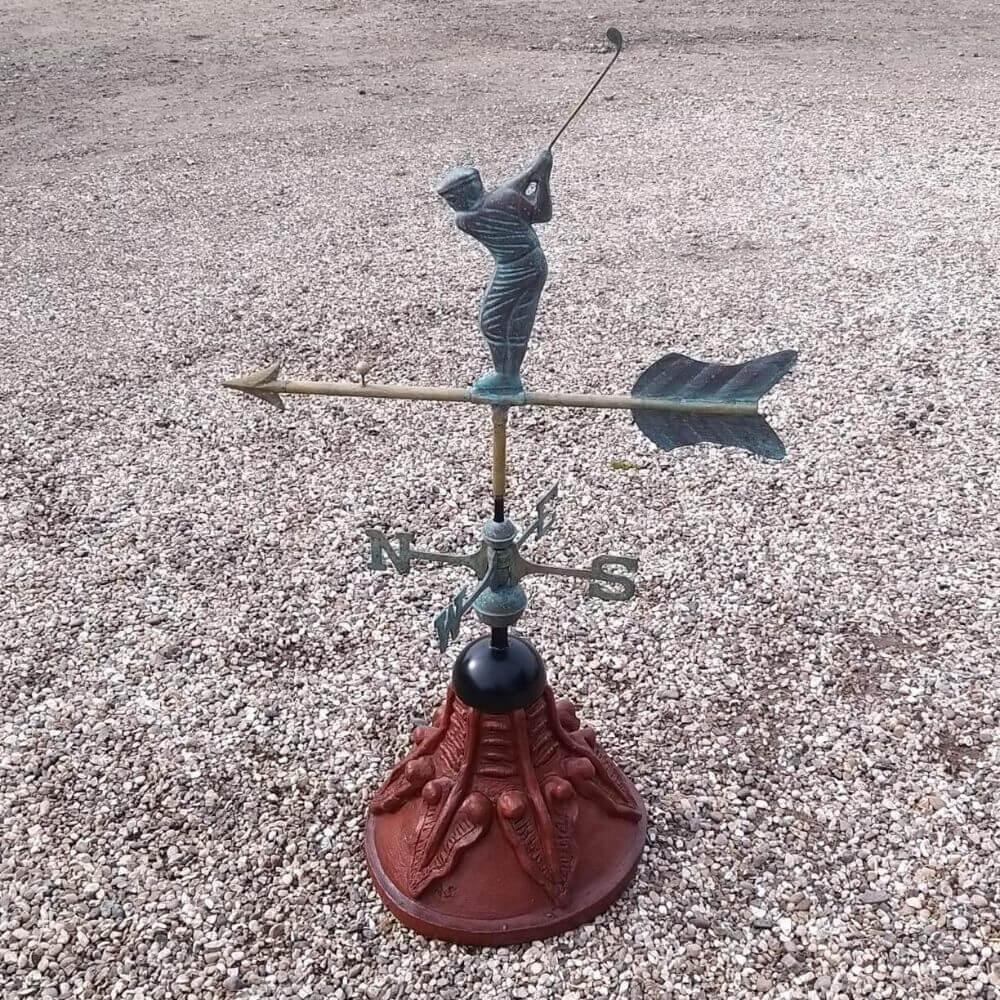 Golfer weathervane fixed to a round ridge tile capping