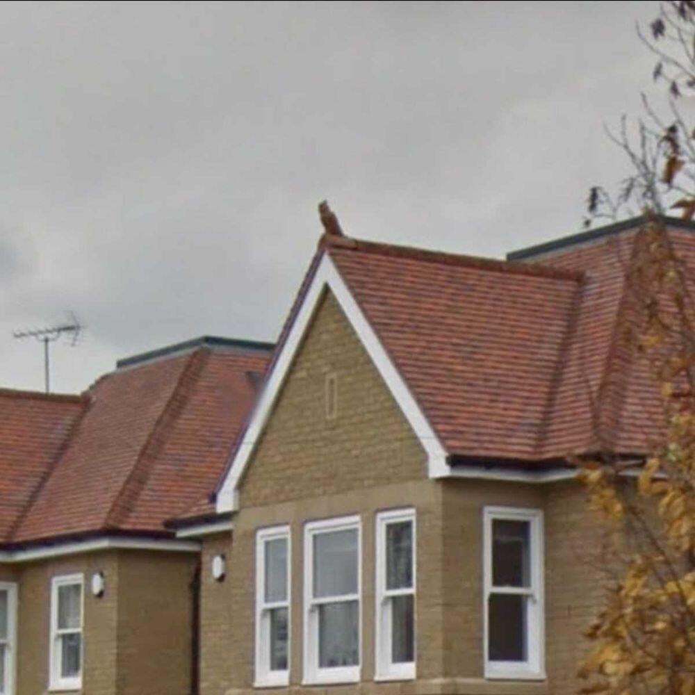 A gable roof that has an owl roof finial installed on top of it