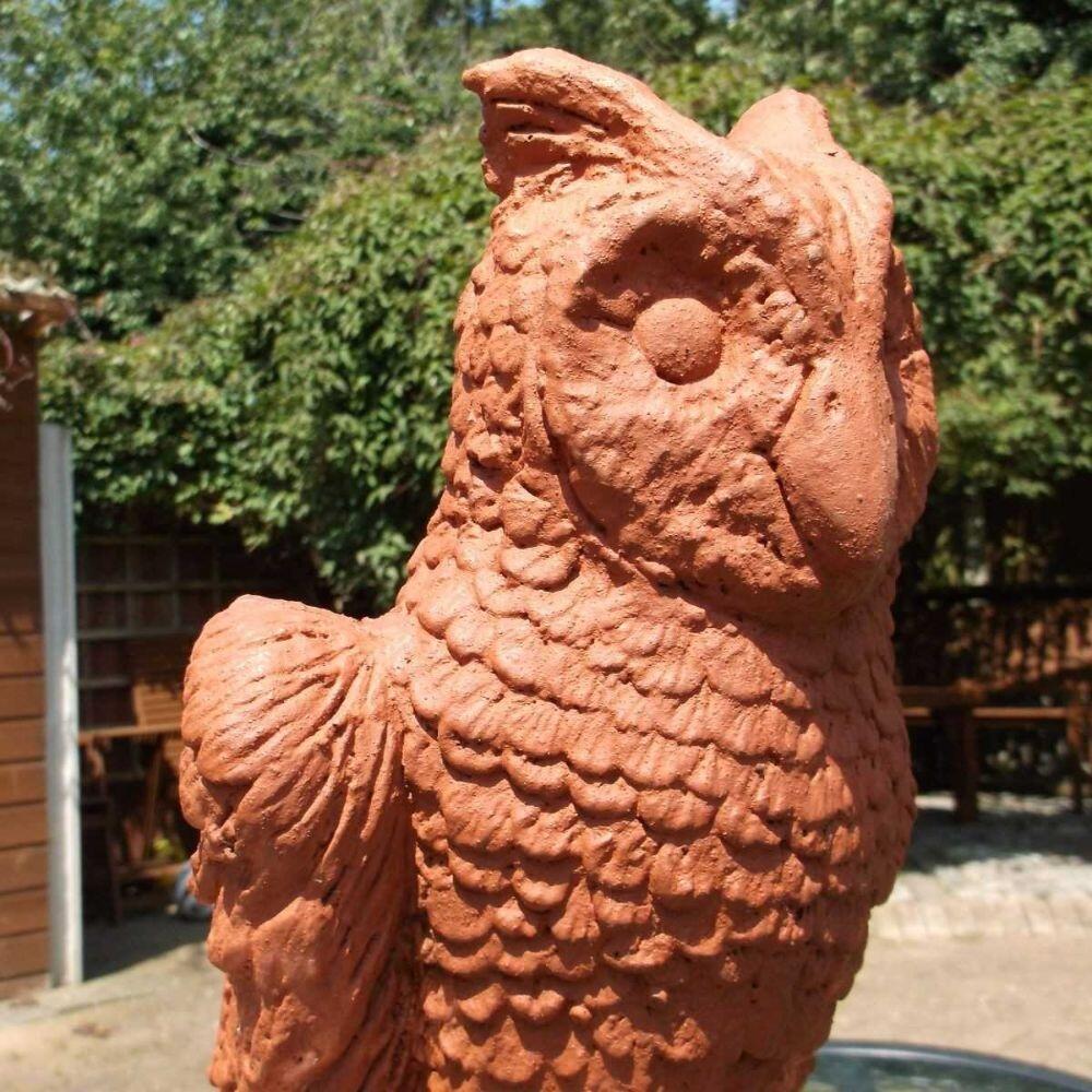 In the garden is displayed a terracotta owl roof finial stop end roof finial