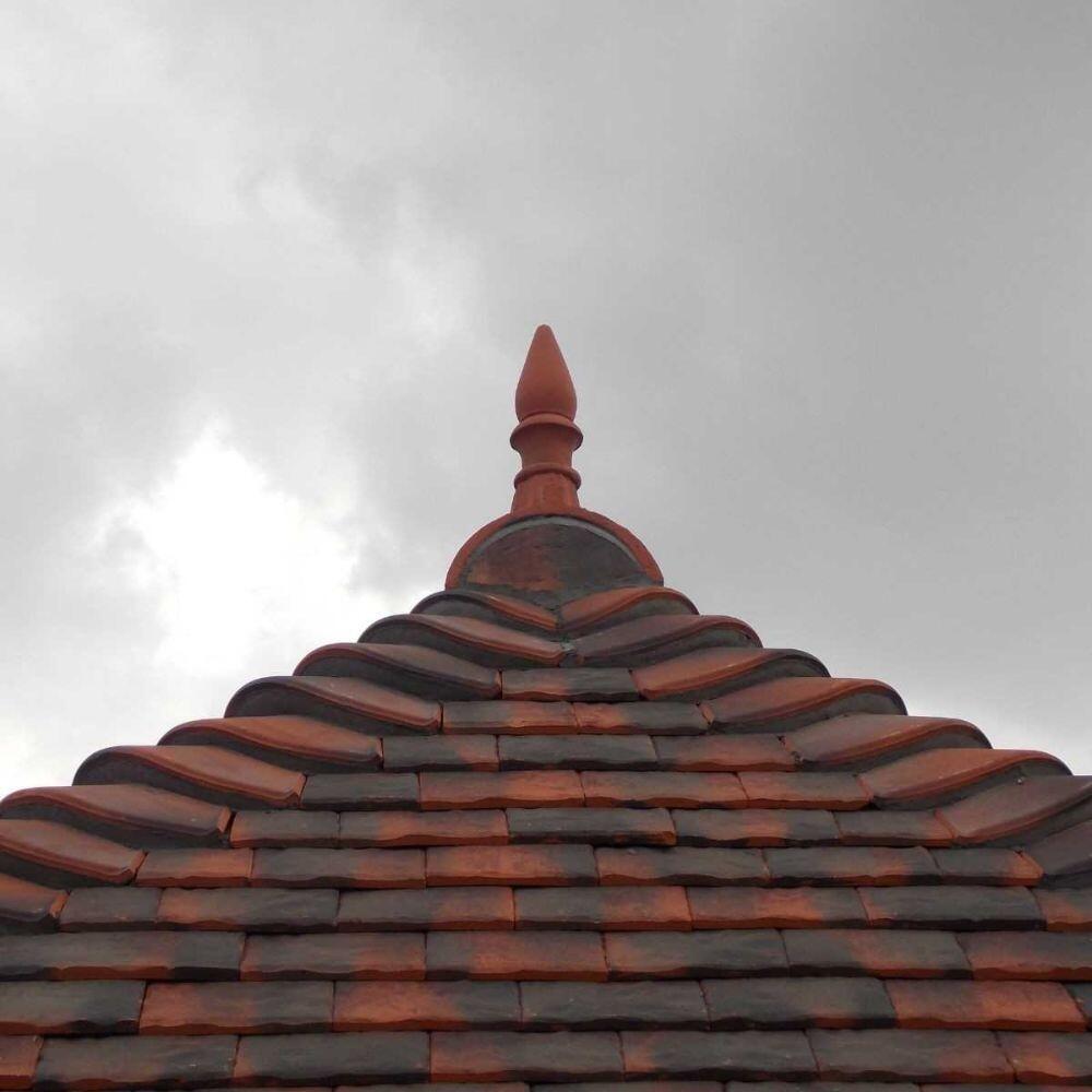 Spike finial half round ridge finial installed on a hip roof