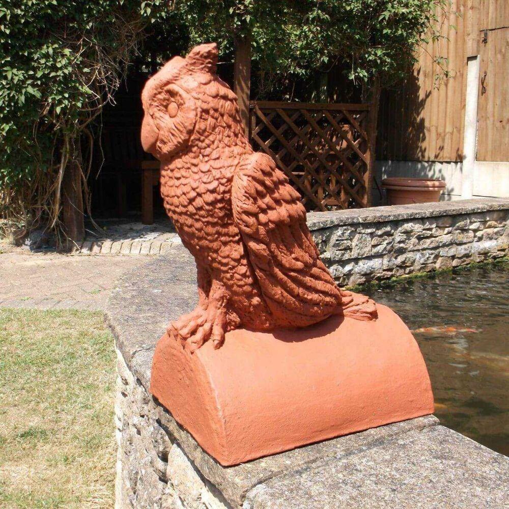 In the garden, there is a terracotta owl finial stop end ridge tile