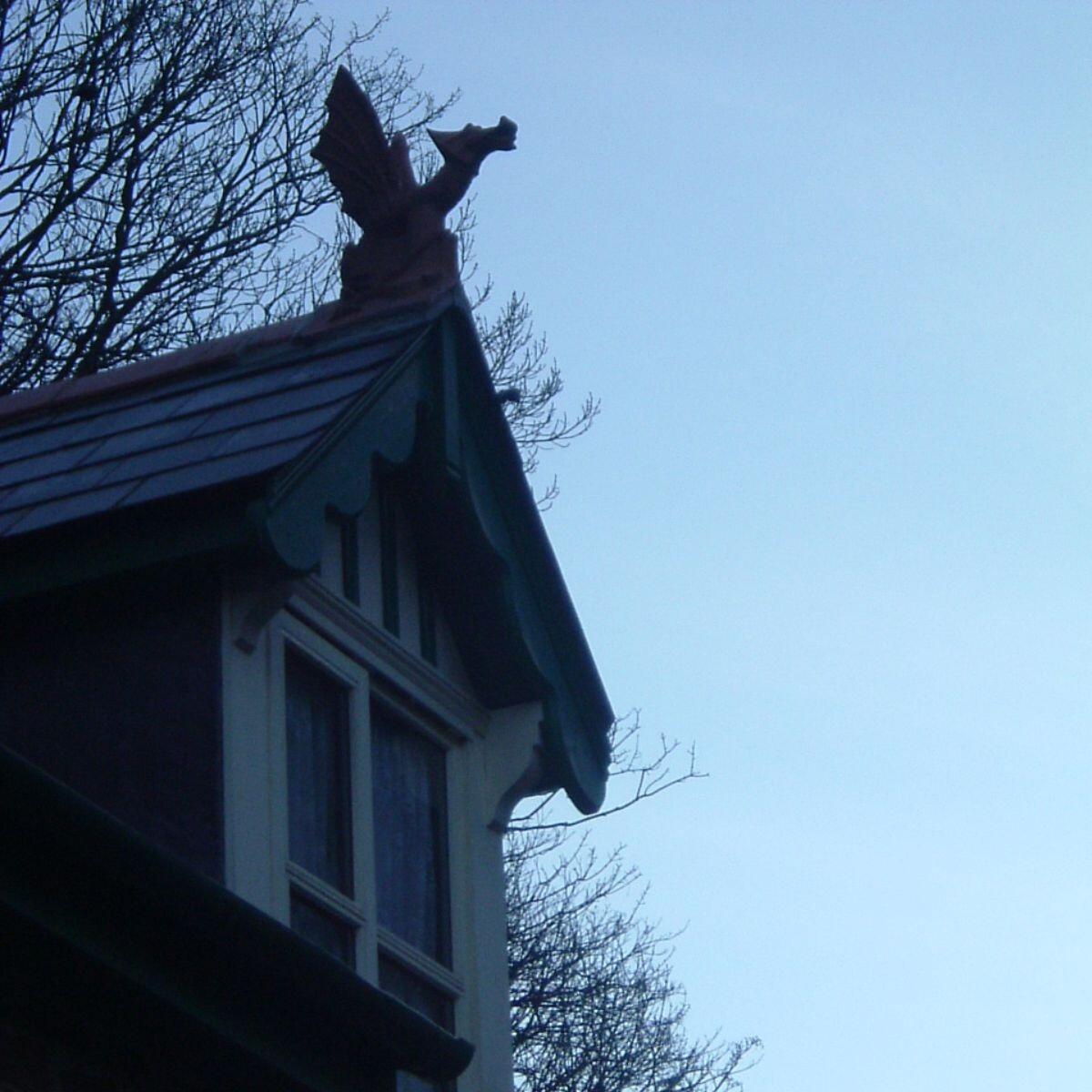Emperor dragon finial installed on a roof overlooking stream