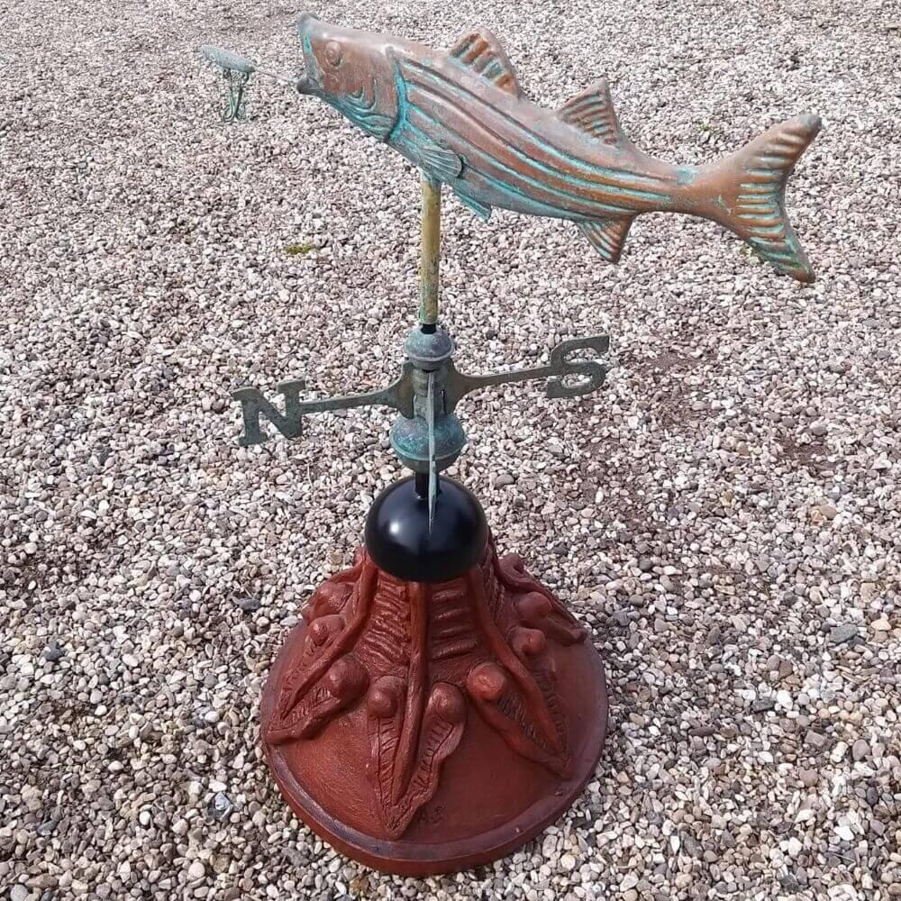 Fish weathervane fixed to a round ridge tile capping