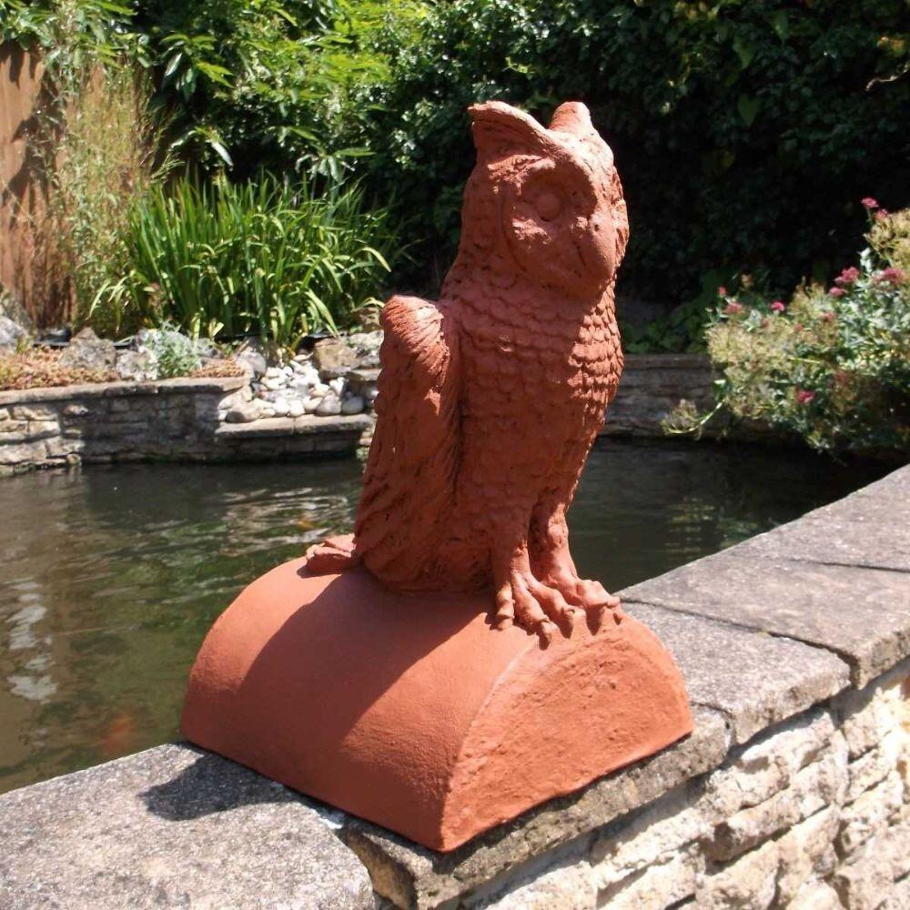 Terracotta owl finial stop end ridge tile in the garden