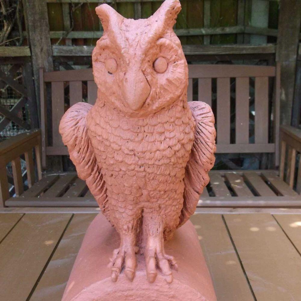 A terracotta owl roof finial stop end with a picture of the item displayed in the garden