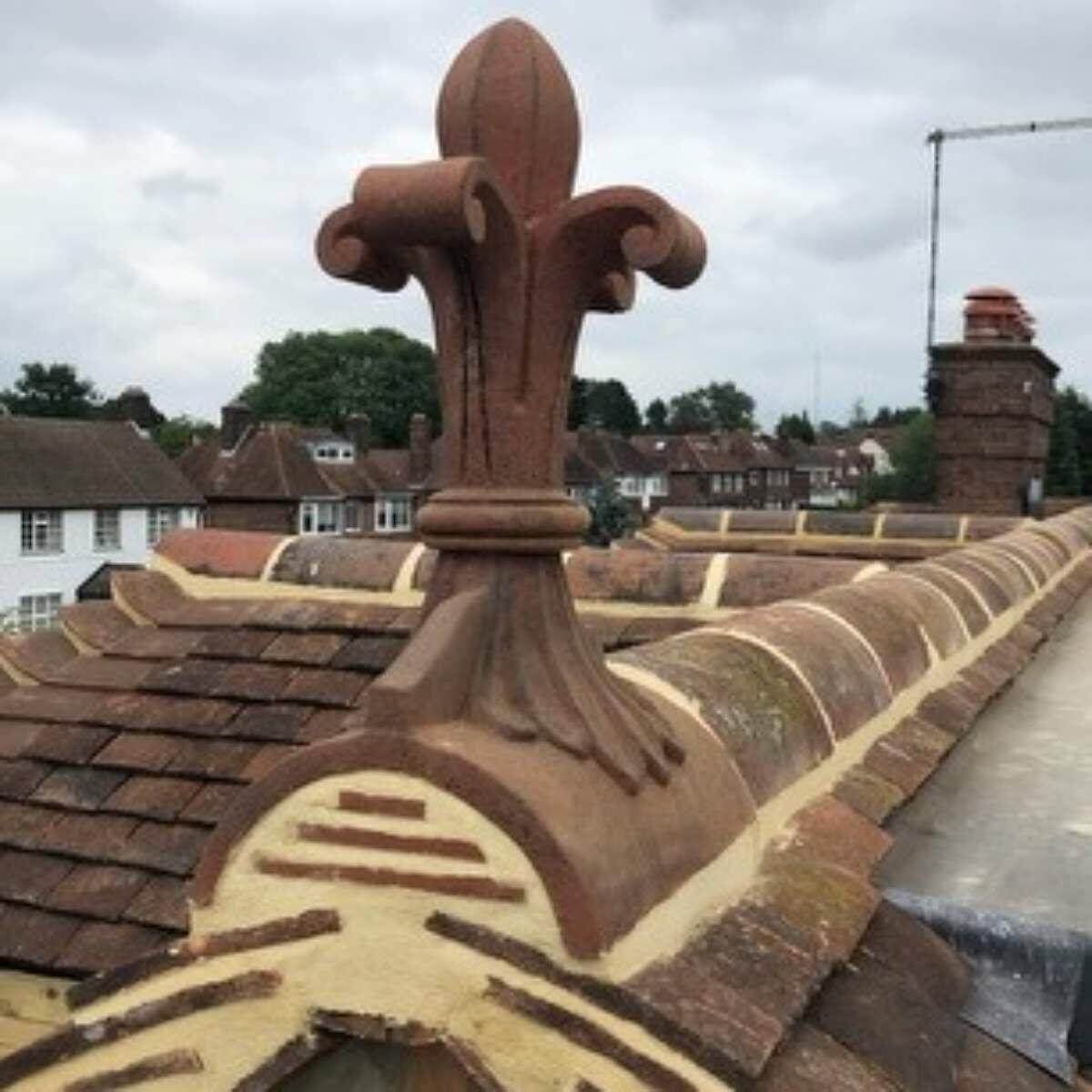 Fleur de lys roof finial colour matched to reclaimed ridge tiles