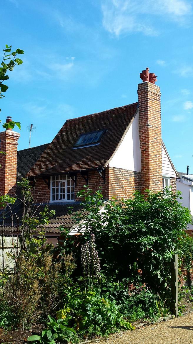 Chimney stack adorned with terracotta chimney pots featuring a dragon sculpture